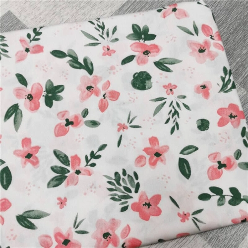A white cotton fabric with pink and green flowers, perfect for a skirt.