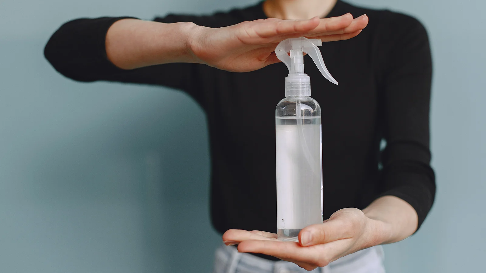 A woman holding a spray bottle.