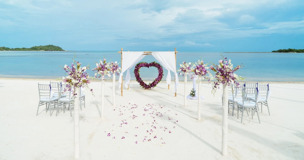 A beach wedding arch shows one way of how to decorate a wedding arch with fabric.