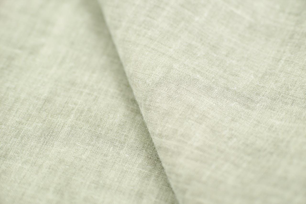 A close up image of a light green linen fabric.