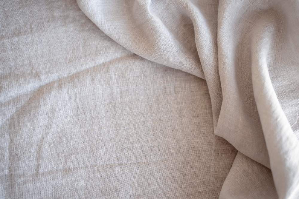 A close up image of a white linen sheet.
