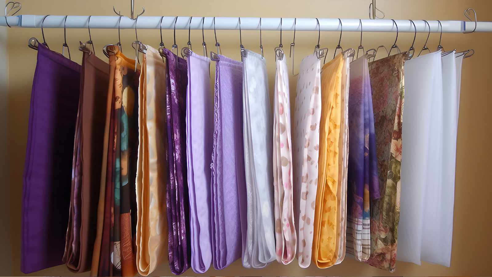 A bunch of different colored fabric hanging on a rack.