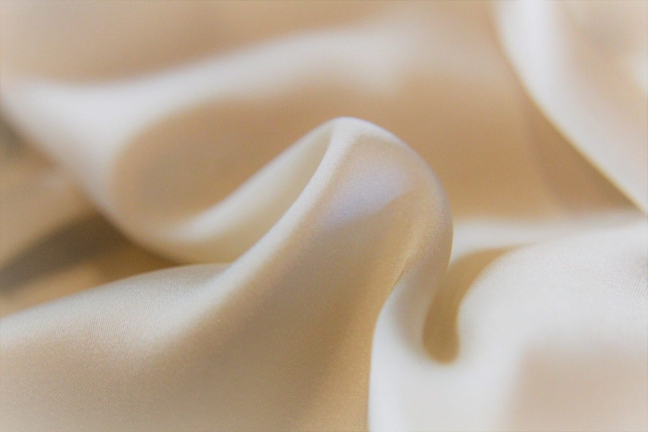 A close up of a white silk fabric.