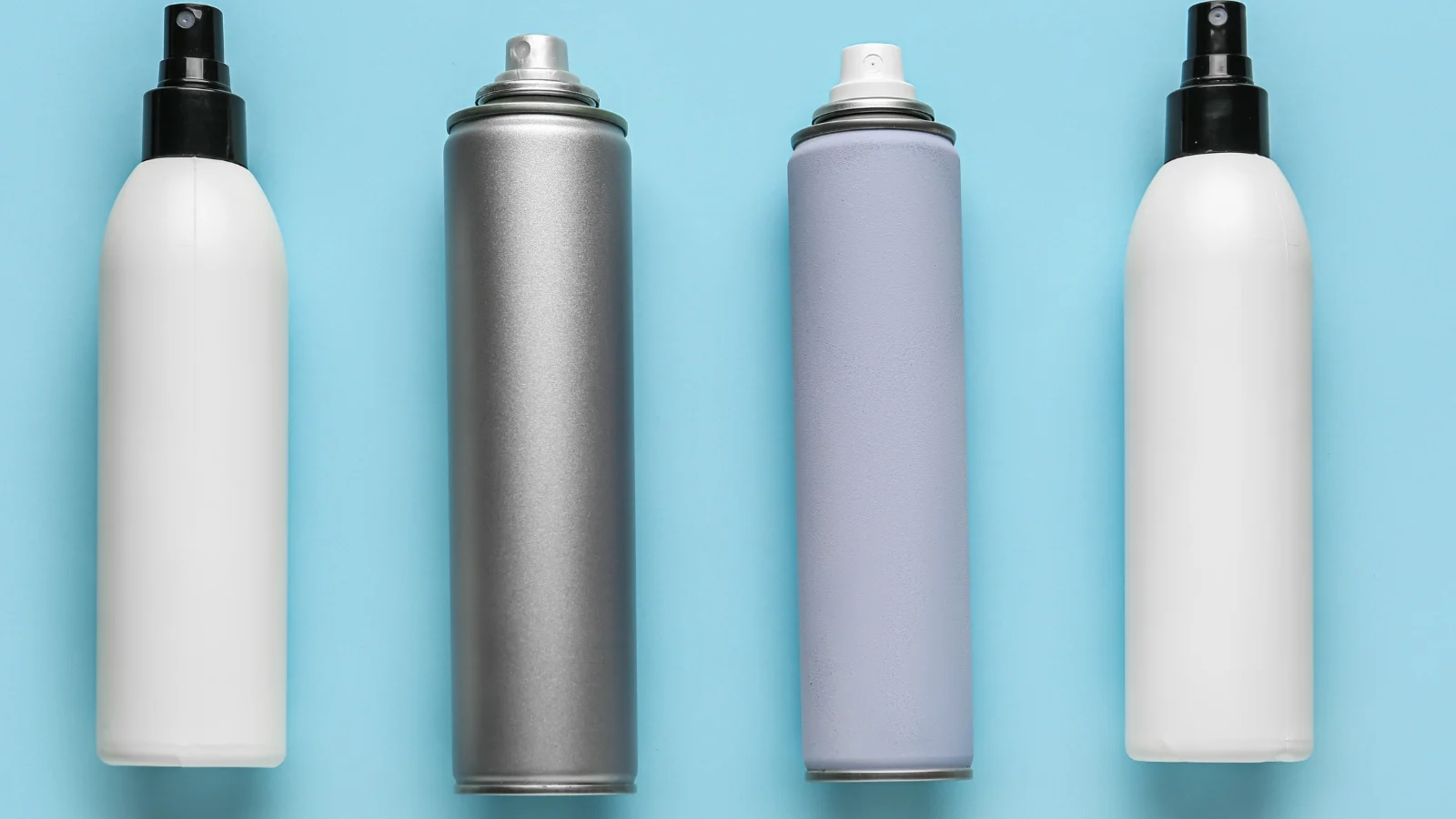 Four different spray bottles on a blue background.