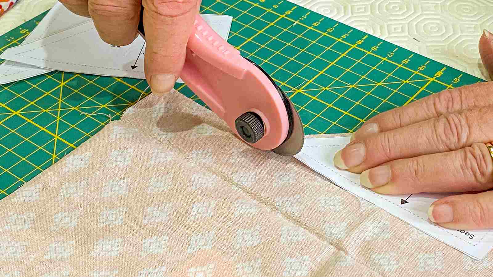 A person cutting a piece of fabric with scissors.