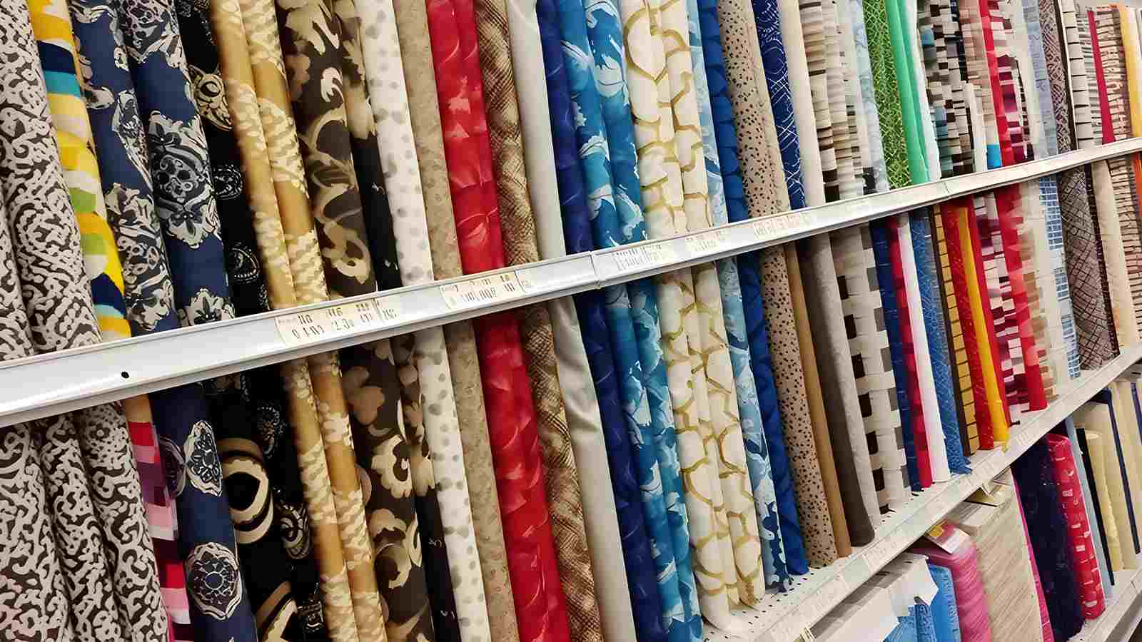 A selection of fabric on a shelf in a store.