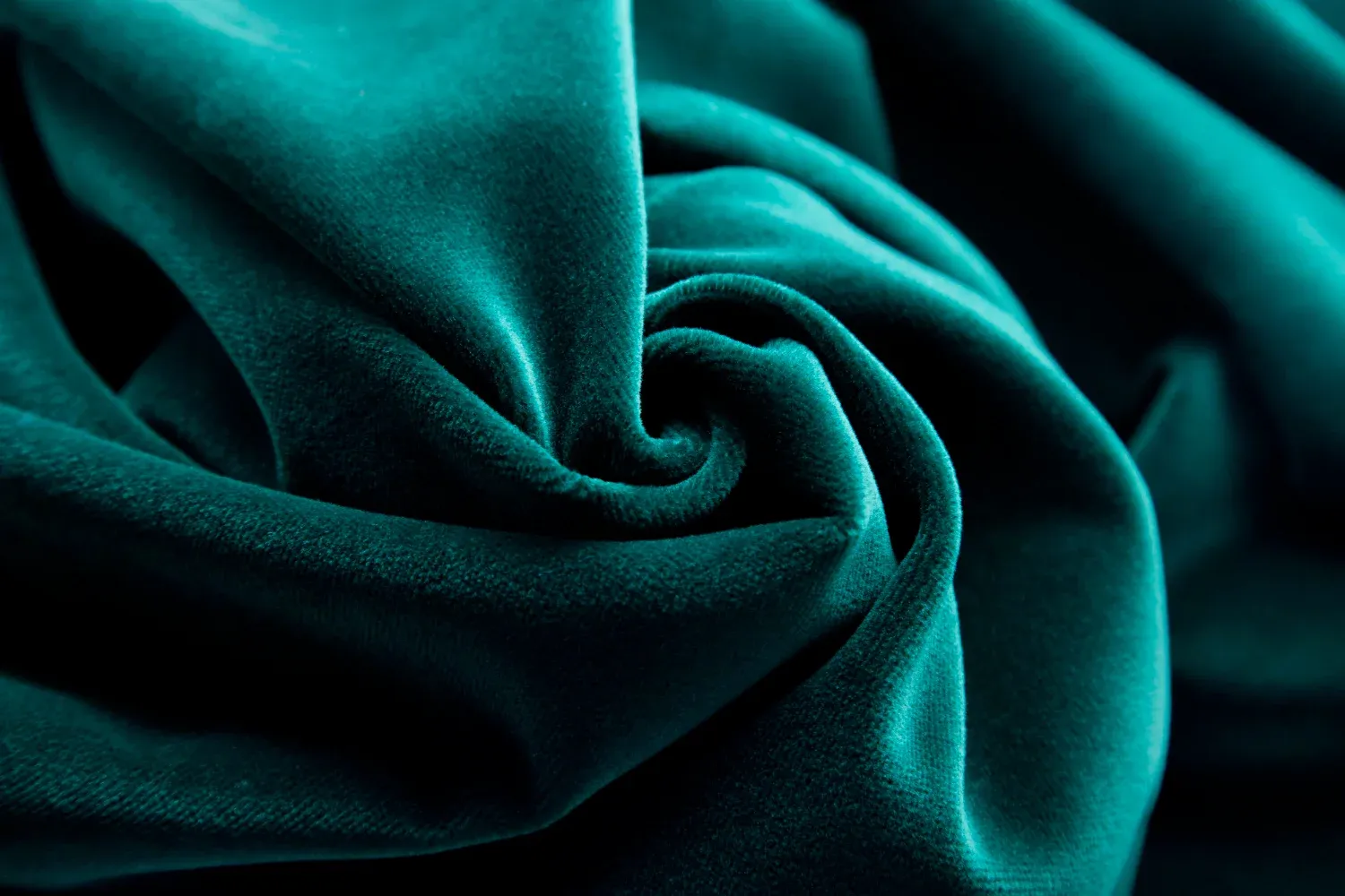 A close up of a teal velvet fabric.